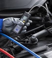 Technician using TEXA SO755H forming gas leak detector probe near vehicle AC lines