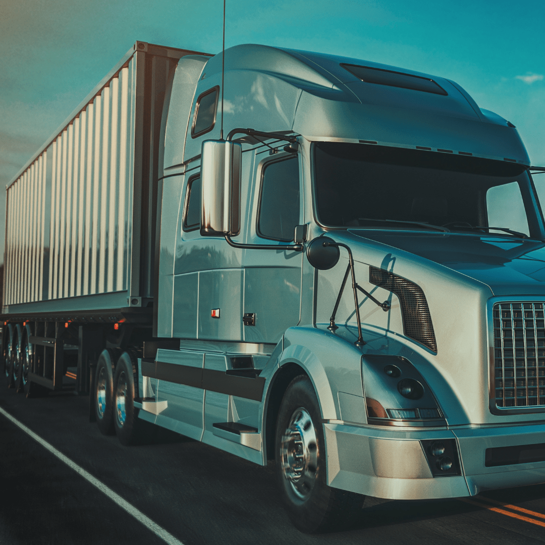 Blue semi-truck on a road with a clear sky